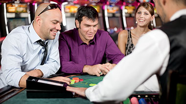A young woman looks on as two blackjack players play at Argosy Casino Alton.